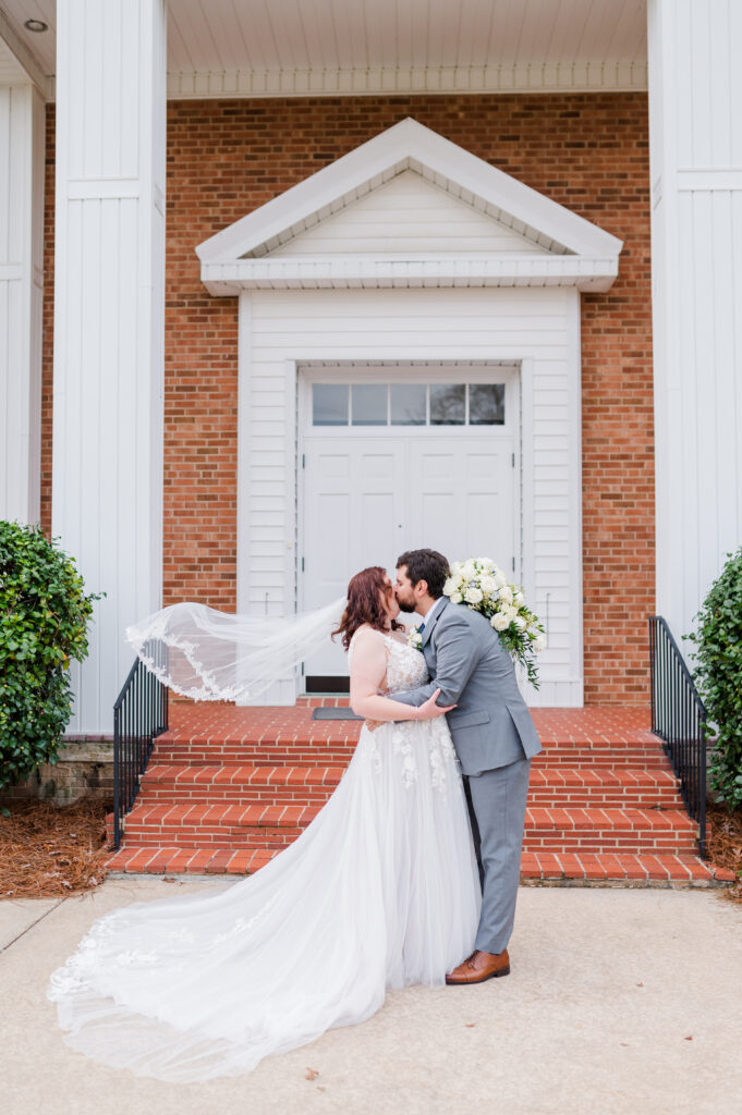 couple kissing in front of church