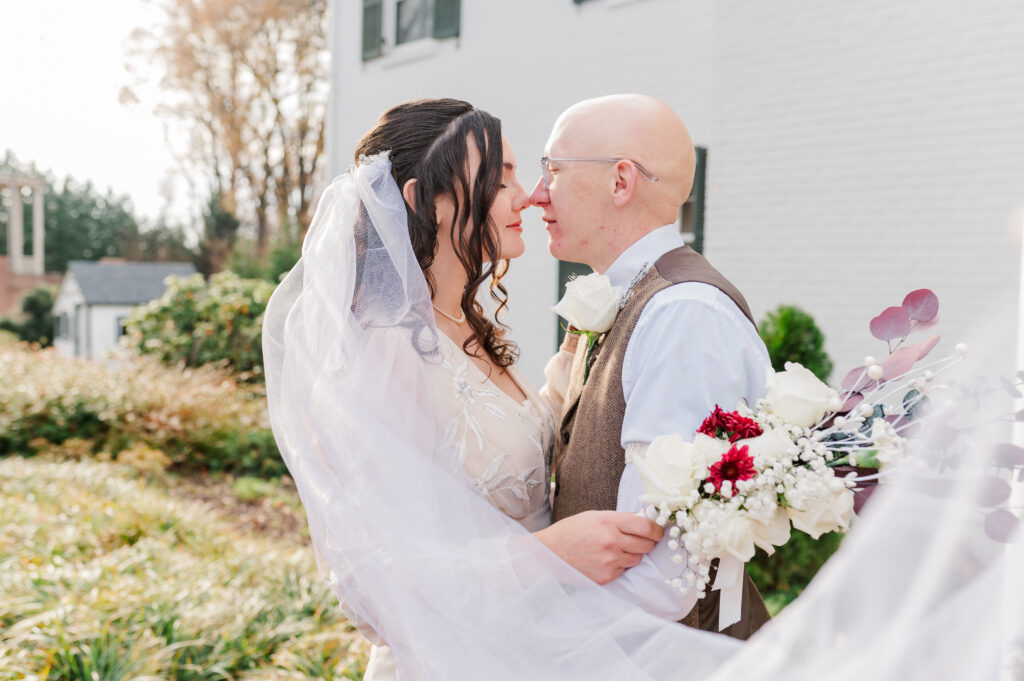 bride and groom nose to nose with veil