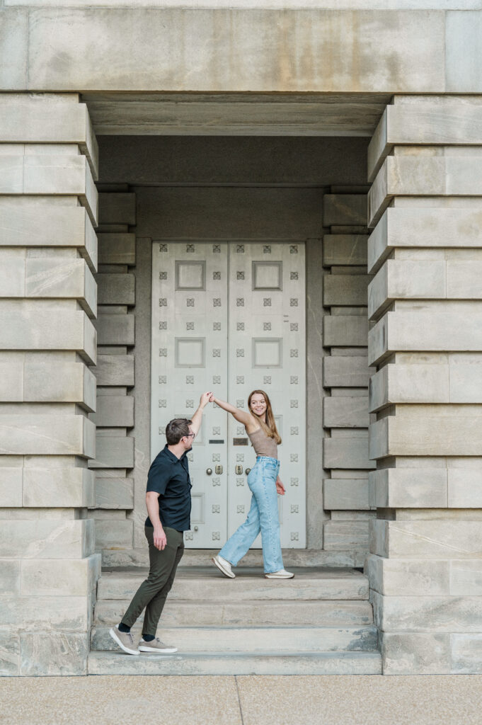 groom leads bride on steps engagement session raleigh