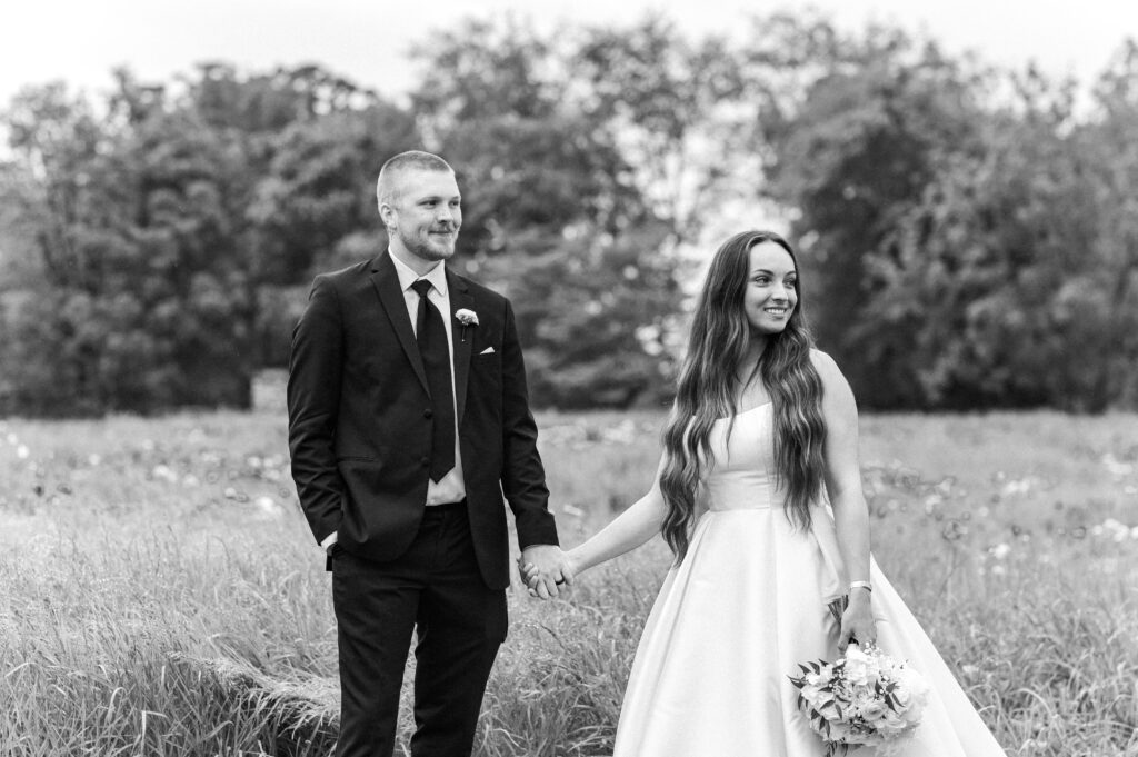 Bride and groom portraits flower field rainy b/w