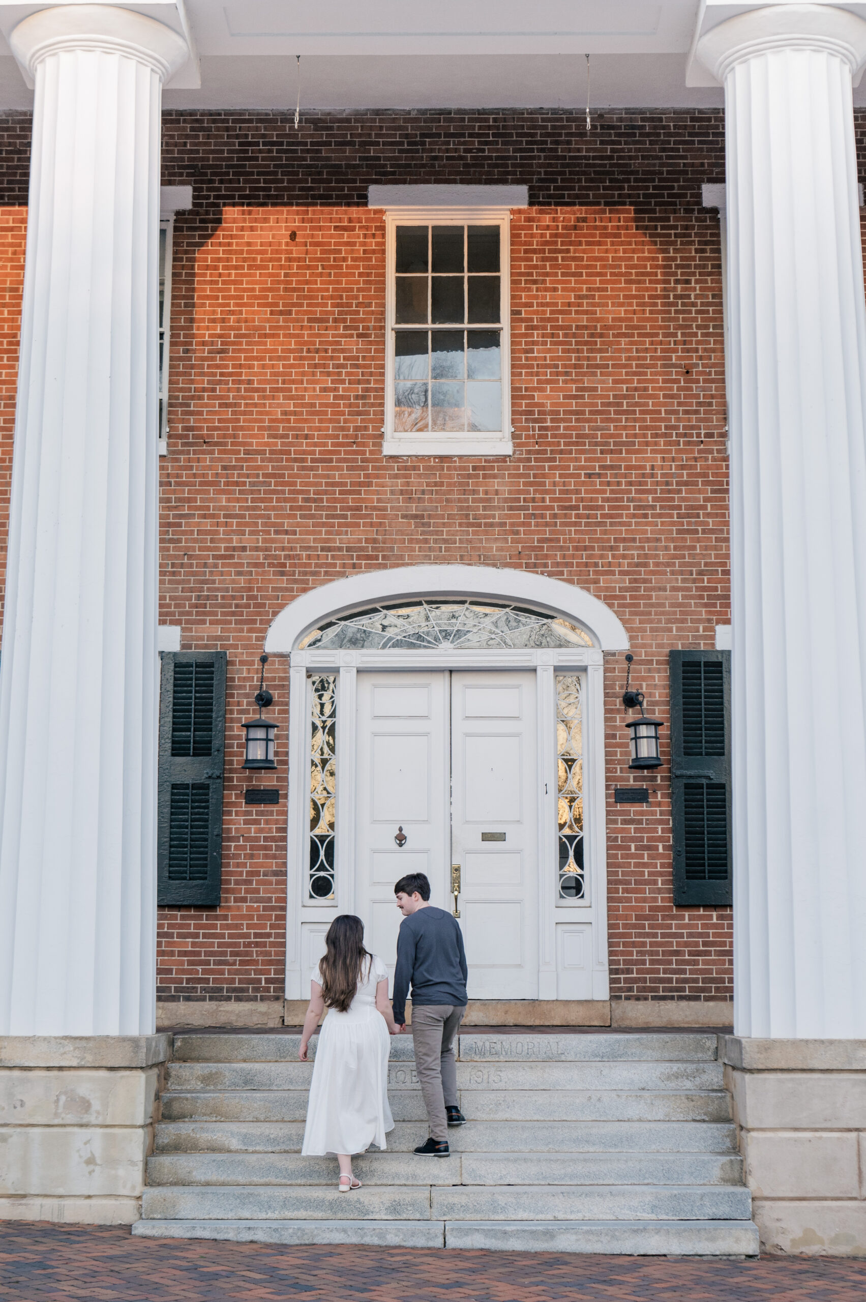 White columns brick building engagement photos