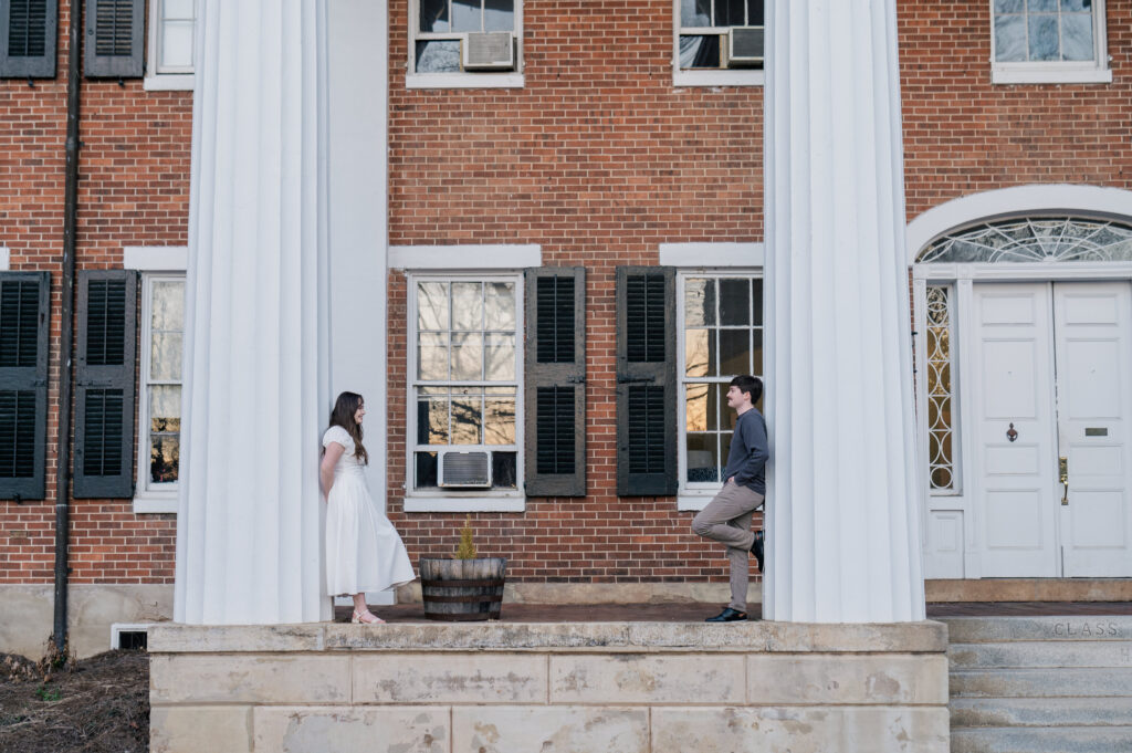 White columns brick building engagement photos